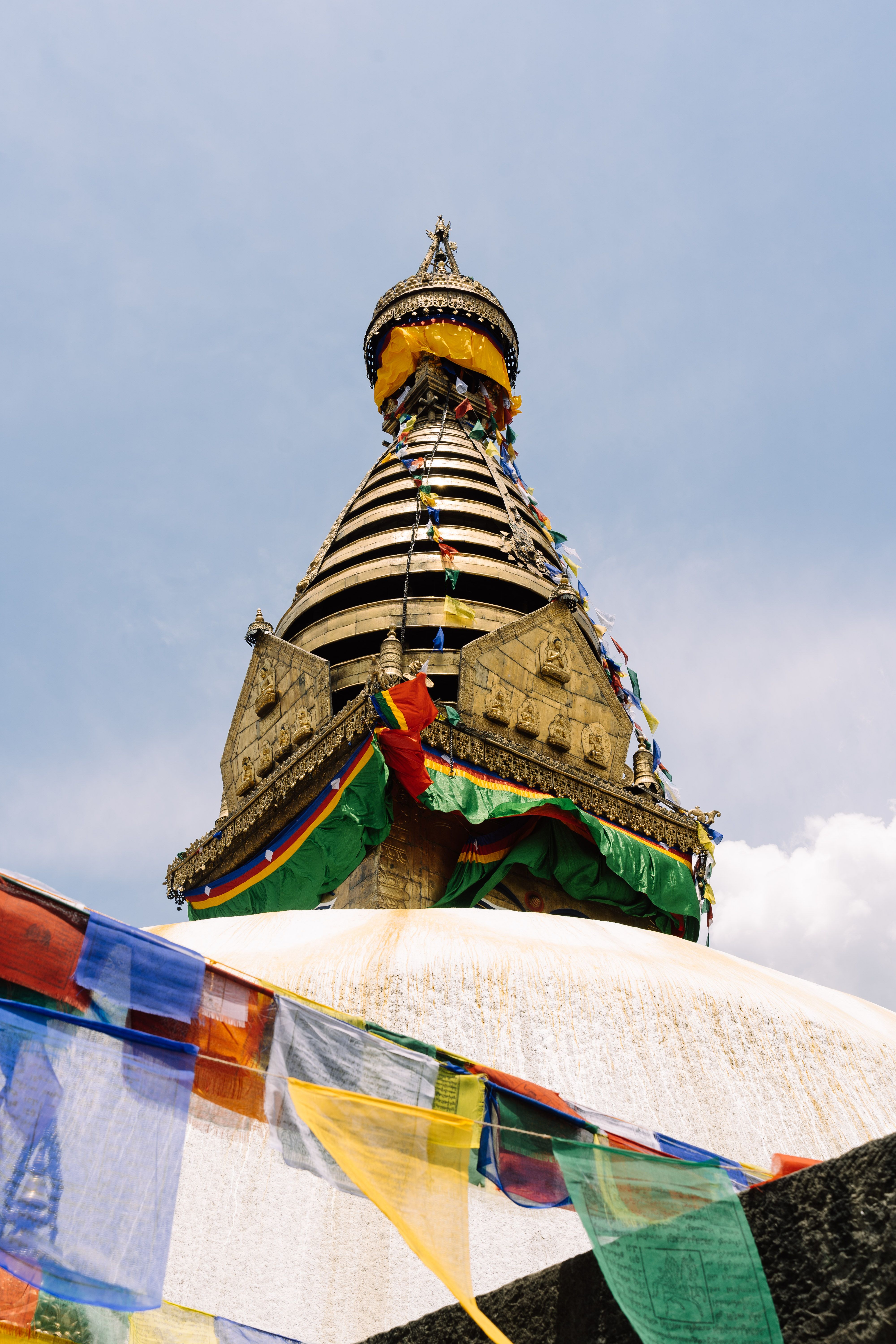 Swayambhunath Stupa with vibrant prayer flags against a clear sky in Kathmandu, Nepal.