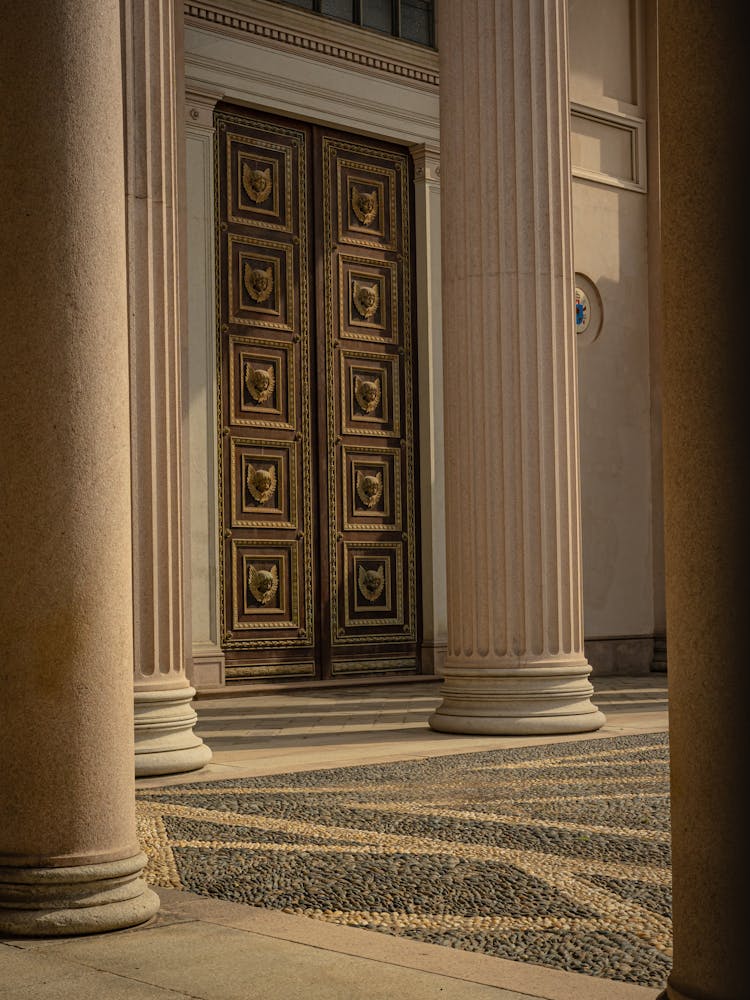 Wooden Door Near Concrete Pillars