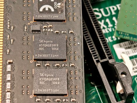 Detailed view of integrated circuits and RAM on a computer motherboard, showing electronic components.