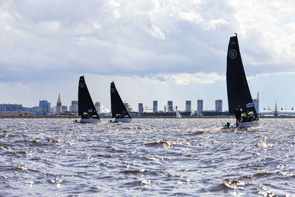 Amazing New York City Dinner Cruise on Luxury Yacht with Live Music Review 2026 - Sailboats competing in a race with urban skyline in the background on a clear day.