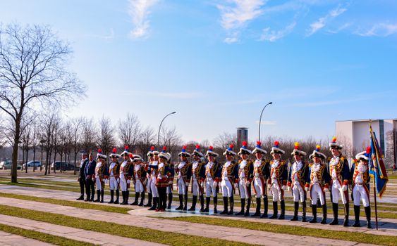 A traditional parade with men in formal ceremonial attire held outdoors in Berlin, Germany.