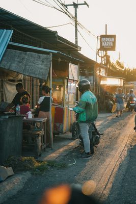 Street market scene at sunset with a food stall