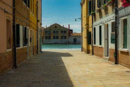 威尼斯迷人的狭窄小巷通向一条风景秀丽的水道，映衬着明亮的天空