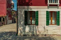 威尼斯迷人的建筑街景，以其彩色外墙和绿色百叶窗展示着独特魅力