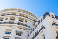 Low-angle view of an impressive building facade against a clear blue sky, showcasing architectural details.
