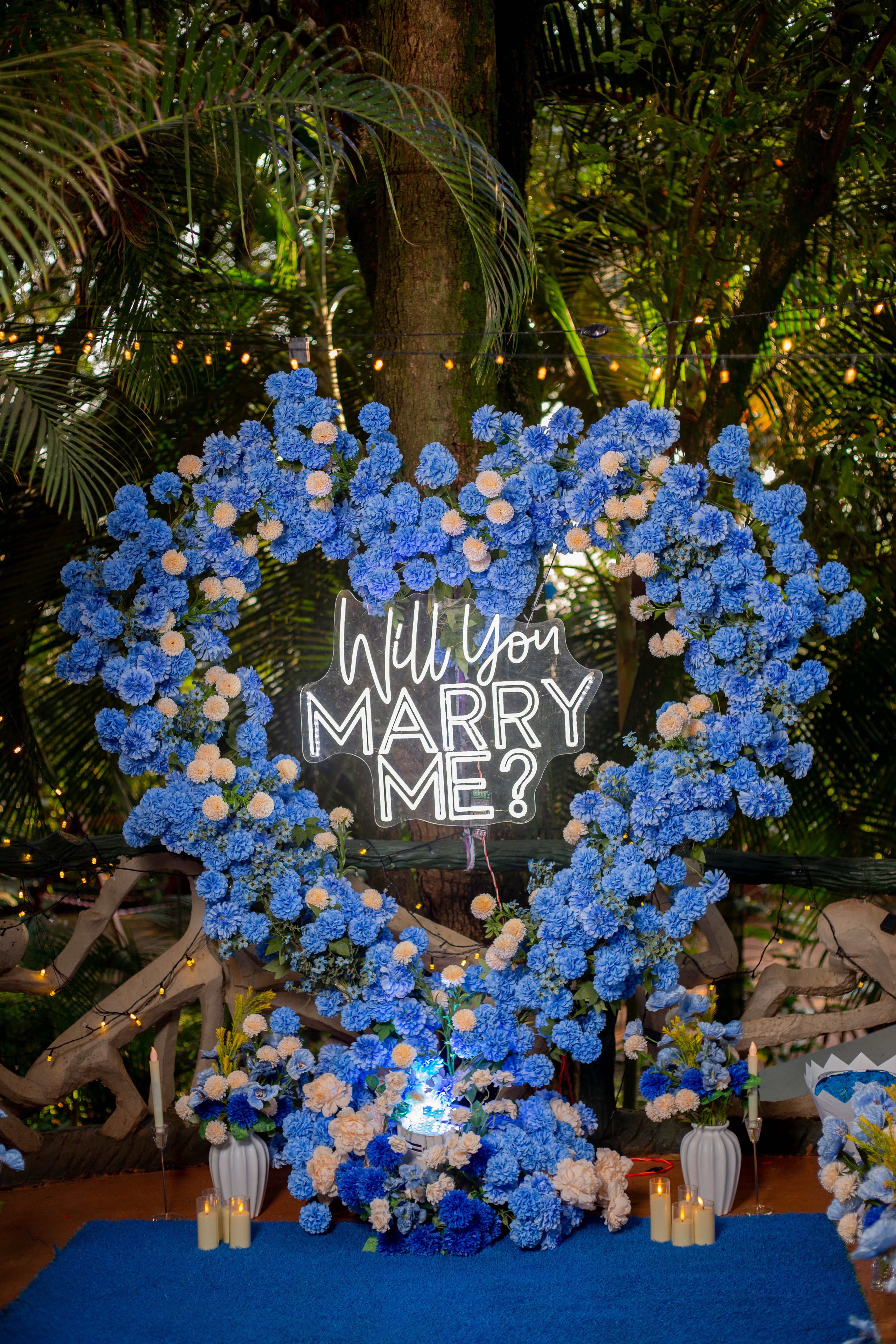 Heart-shaped floral arrangement featuring 'Will You Marry Me?' sign, ideal for romantic proposals.