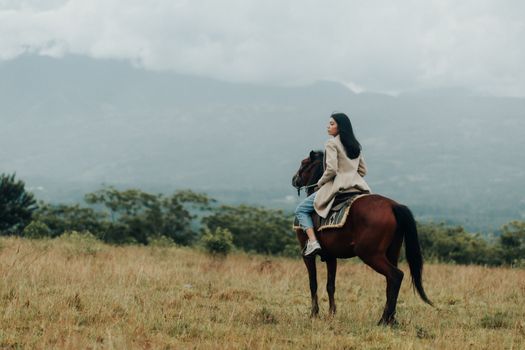 A woman enjoying a serene horseback ride in a misty countryside setting, Philippines.