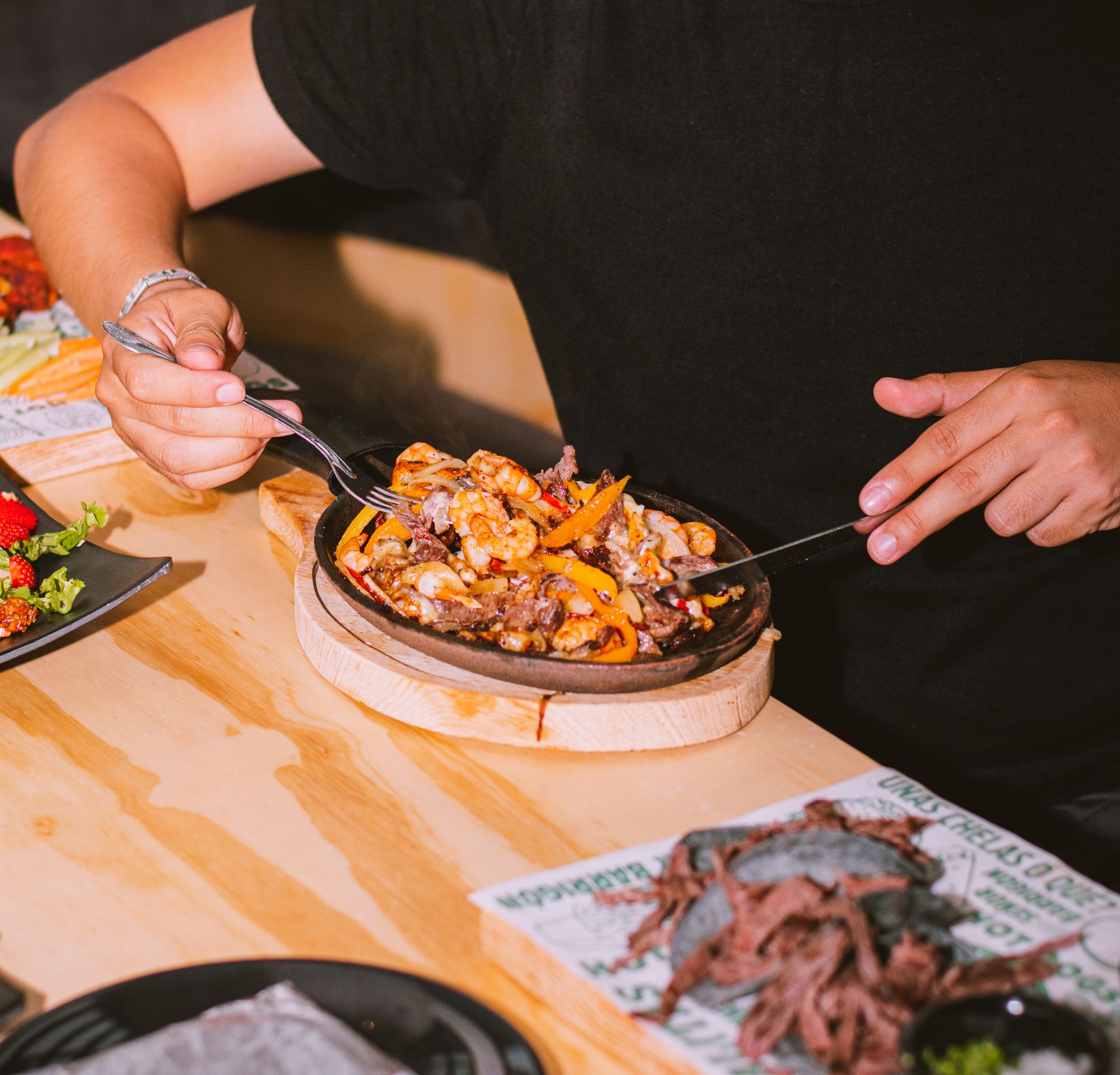 A diner enjoying fresh sizzling shrimp fajitas at an open air restaurant