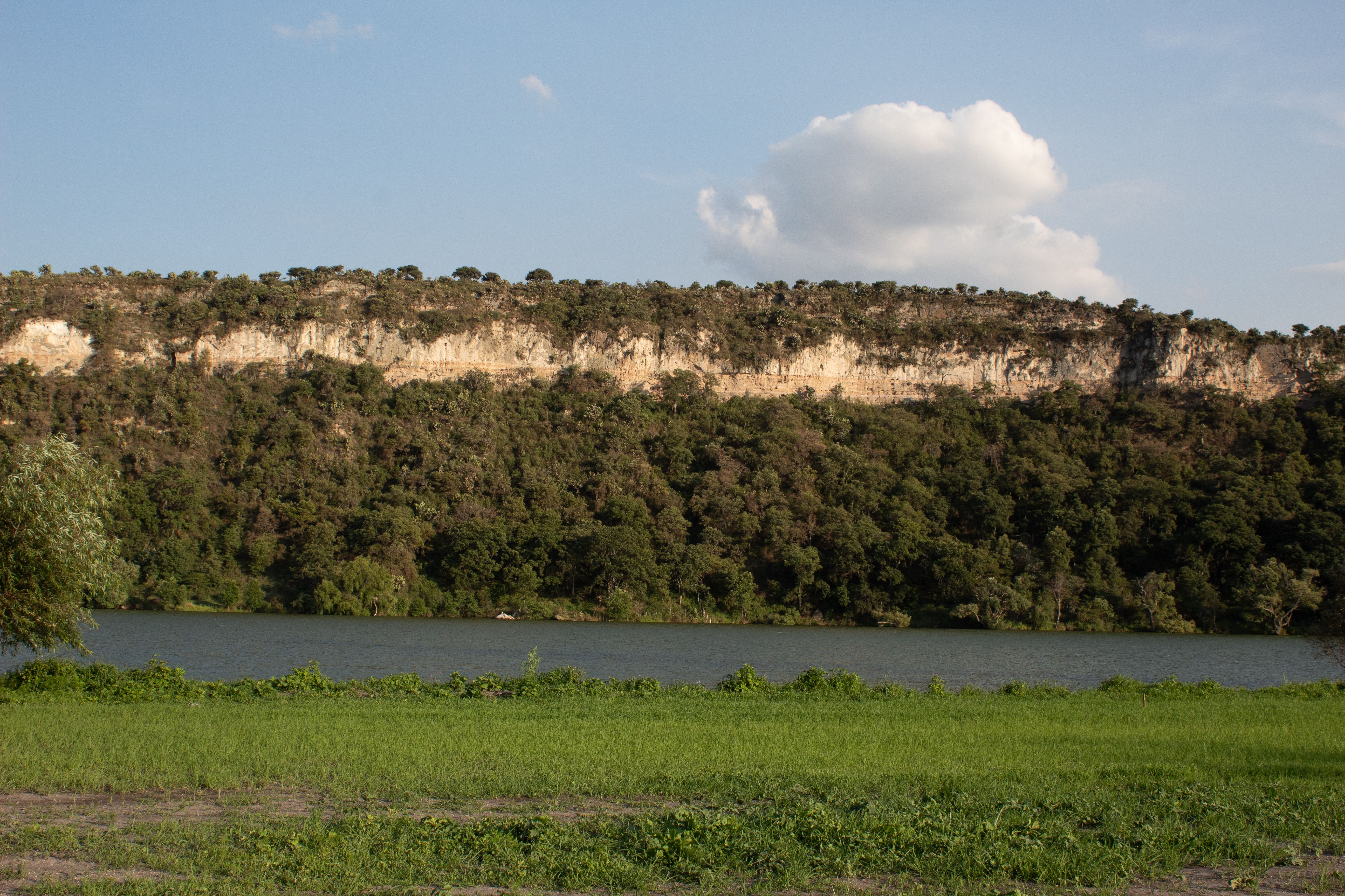 Peaceful landscape of cliffs and forest by the lake in Villa del Carbón, México.