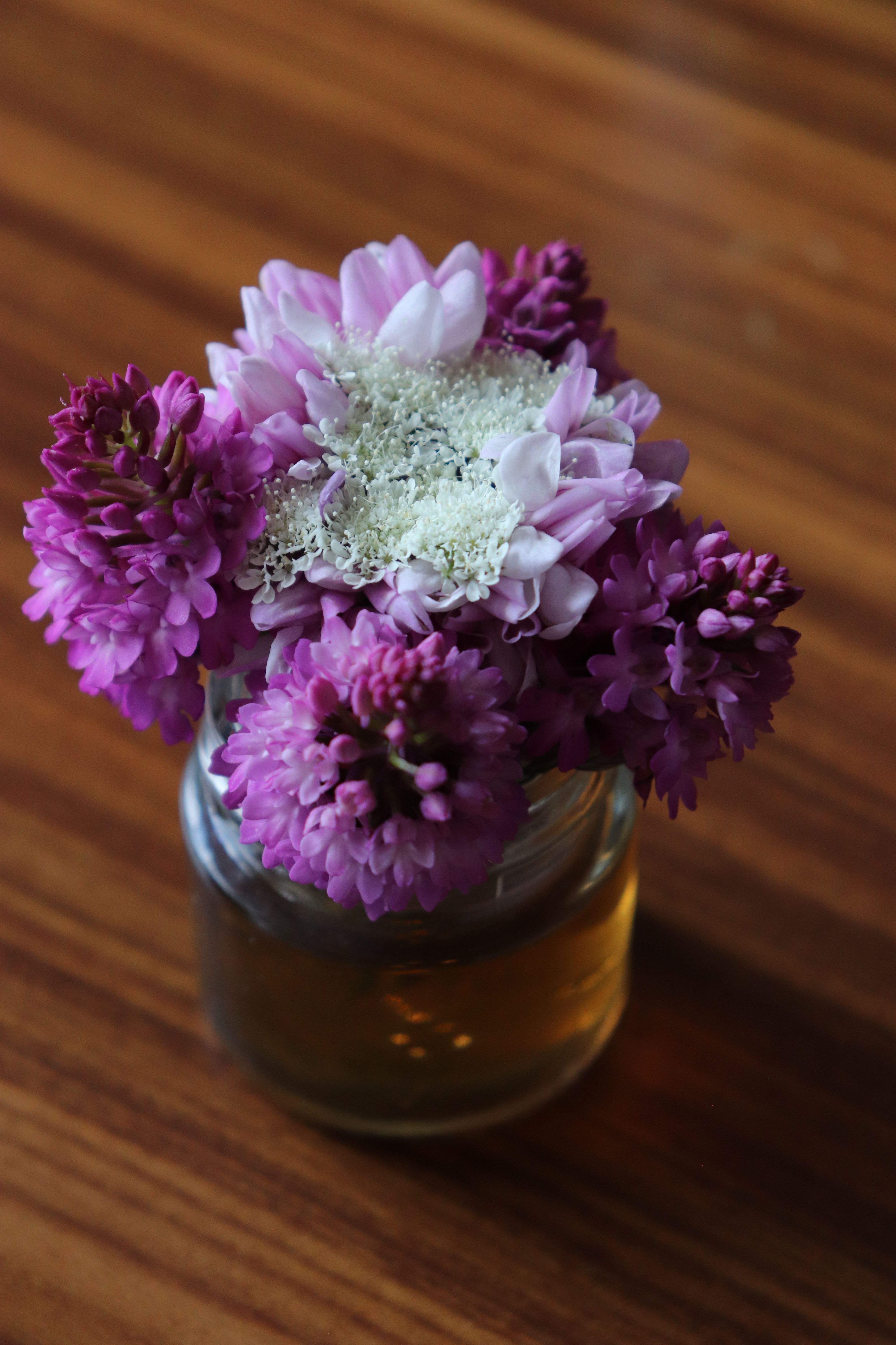 [ColoSach]-top-view-of-pink-chrysanthemums-in-a-jar-on-a-wooden-table,-warm-lighting-enhances-floral-details.