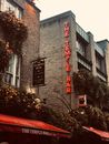 都柏林寺庙酒吧那充满活力的外观，用鲜花和霓虹灯招牌装饰，捕捉了其热闹的气氛