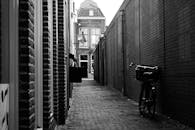 空荡荡的小巷里，单色景观中，砖墙上停着一辆自行车