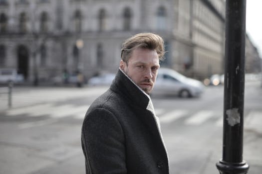 艳阳天里，一位穿着优雅外套的帅哥侧身过马路，看向镜头