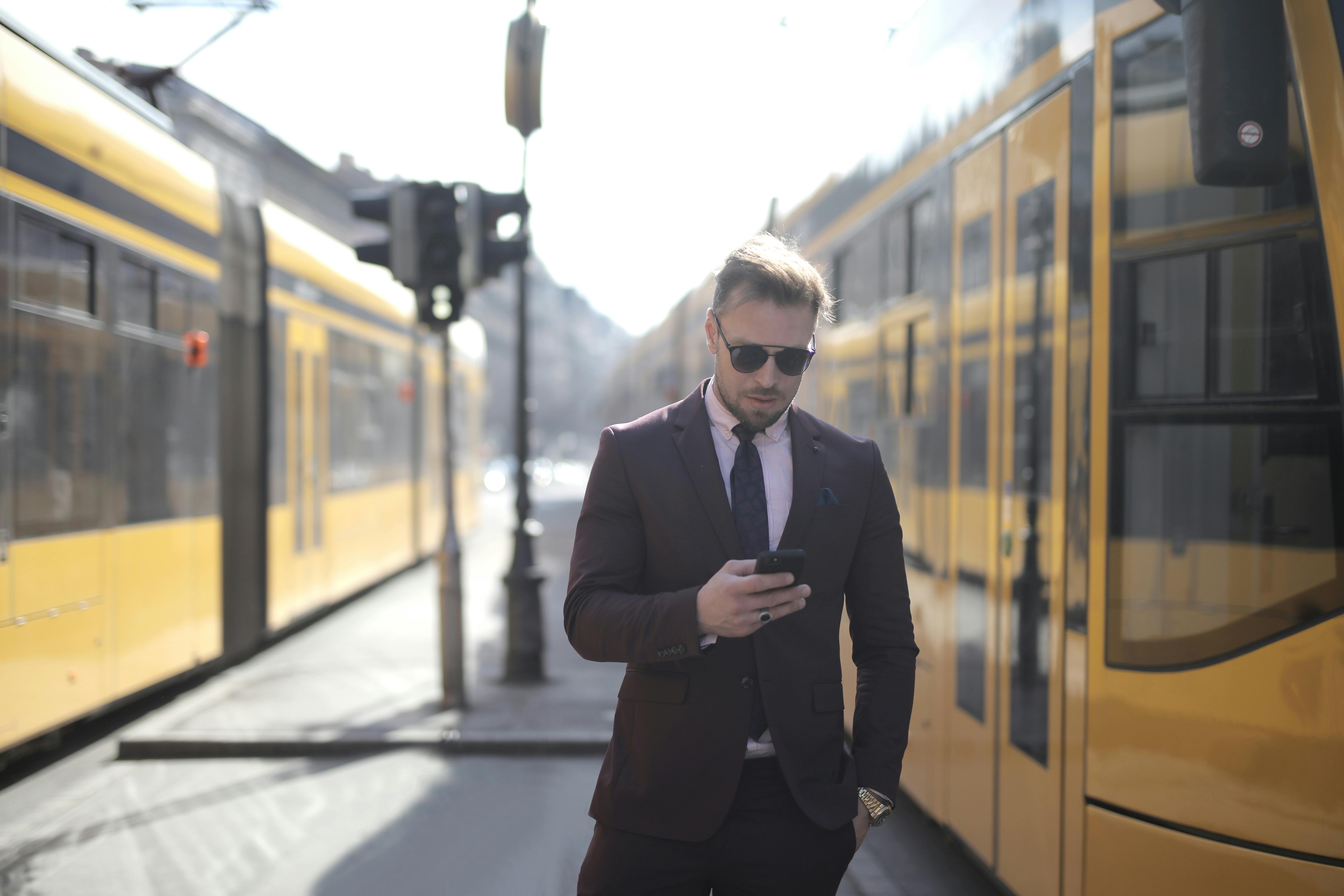 confident businessman using smartphone on street
