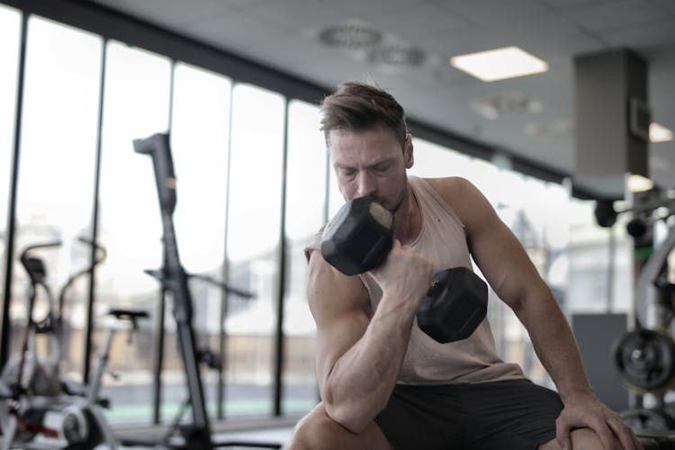 Determined Muscular Sportsman Exercising With Dumbbell