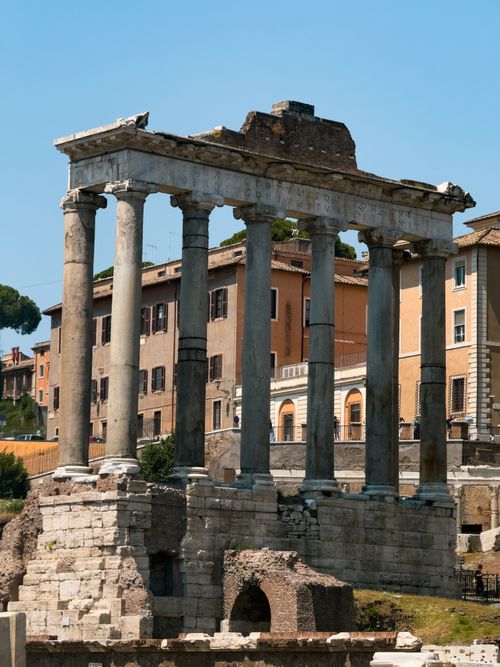 Free Majestic view of ancient Roman temple ruins against a city backdrop in Rome, Italy. Stock Photo