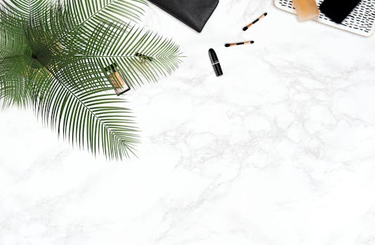 化妆用品以装饰性棕榈叶为特色，平躺在白色大理石背景上，显得时尚
