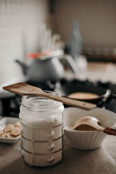 A warm kitchen scene with ingredients being prepared for pancakes.