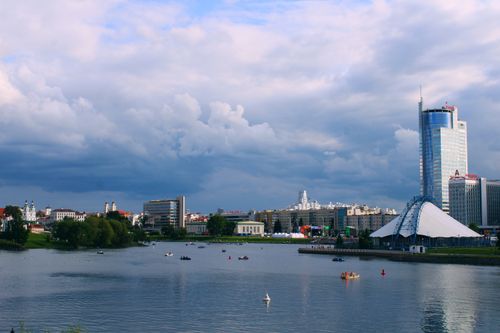 Free Picturesque view of Minsk cityscape along the river under a cloudy sky with modern and historic architecture. Stock Photo