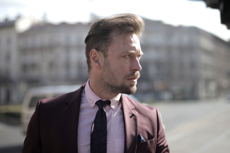 Professional man in suit on city street, looking pensive under daylight. Professional man in suit on city street, looking pensive under daylight.