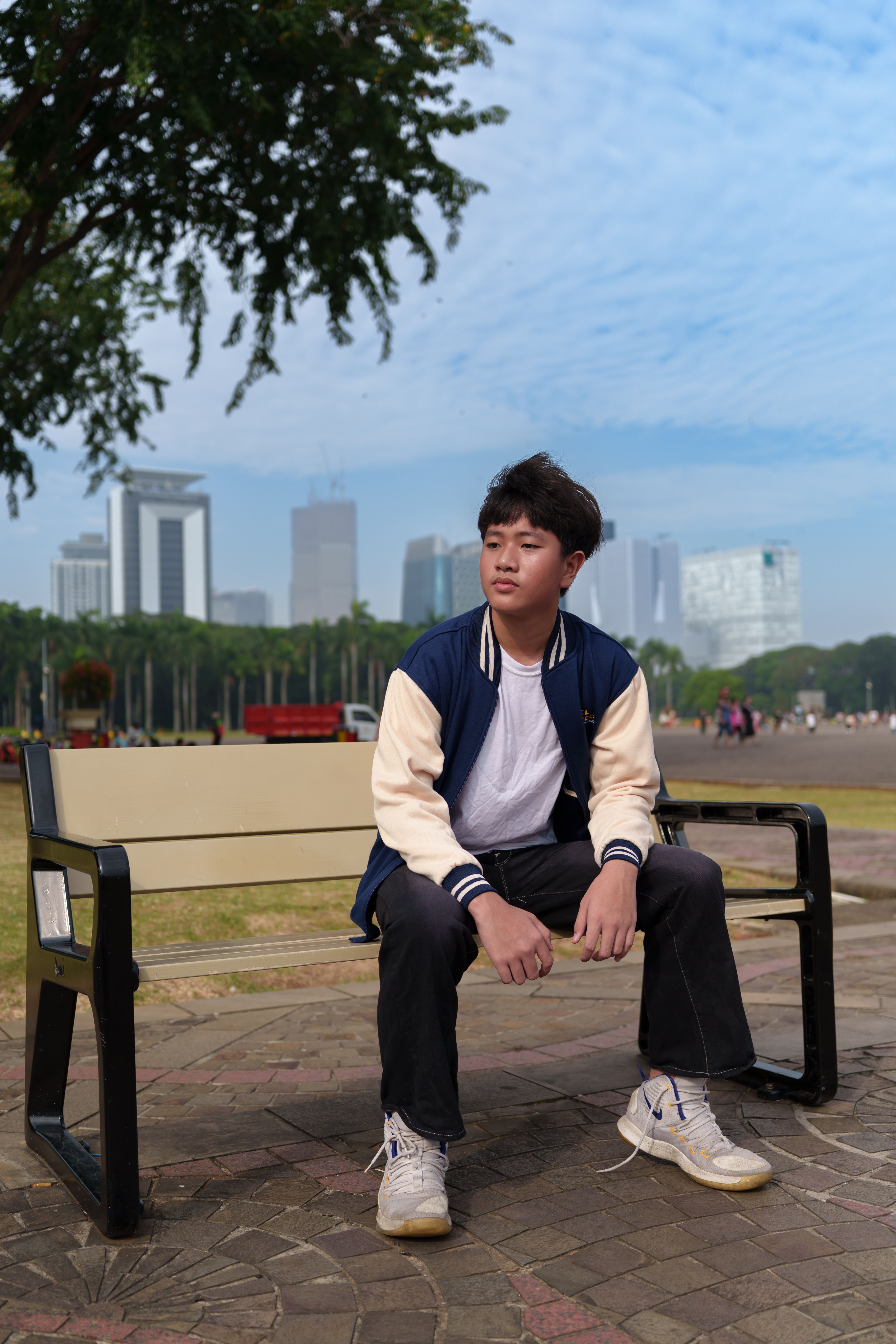 Young Man Sitting on Bench with Jakarta Skyline