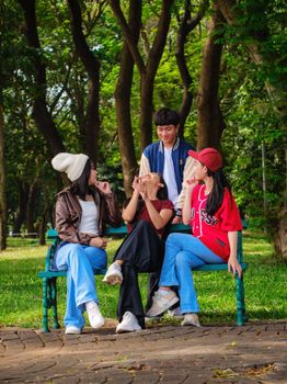 Group of young adults sharing a joyful moment in Suropati Park, Jakarta, Indonesia.
