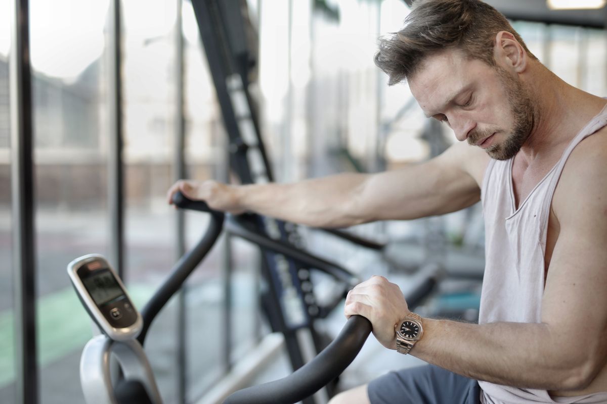 Athlete using an exercise bike for cardio training in a modern gym