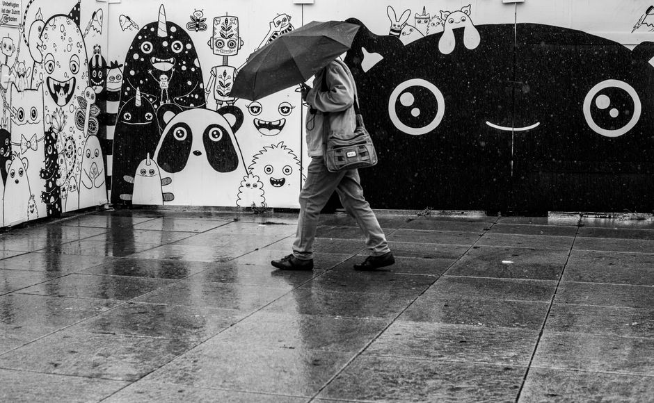 Traveler holding a compact umbrella on a rainy day in Brussels, Belgium