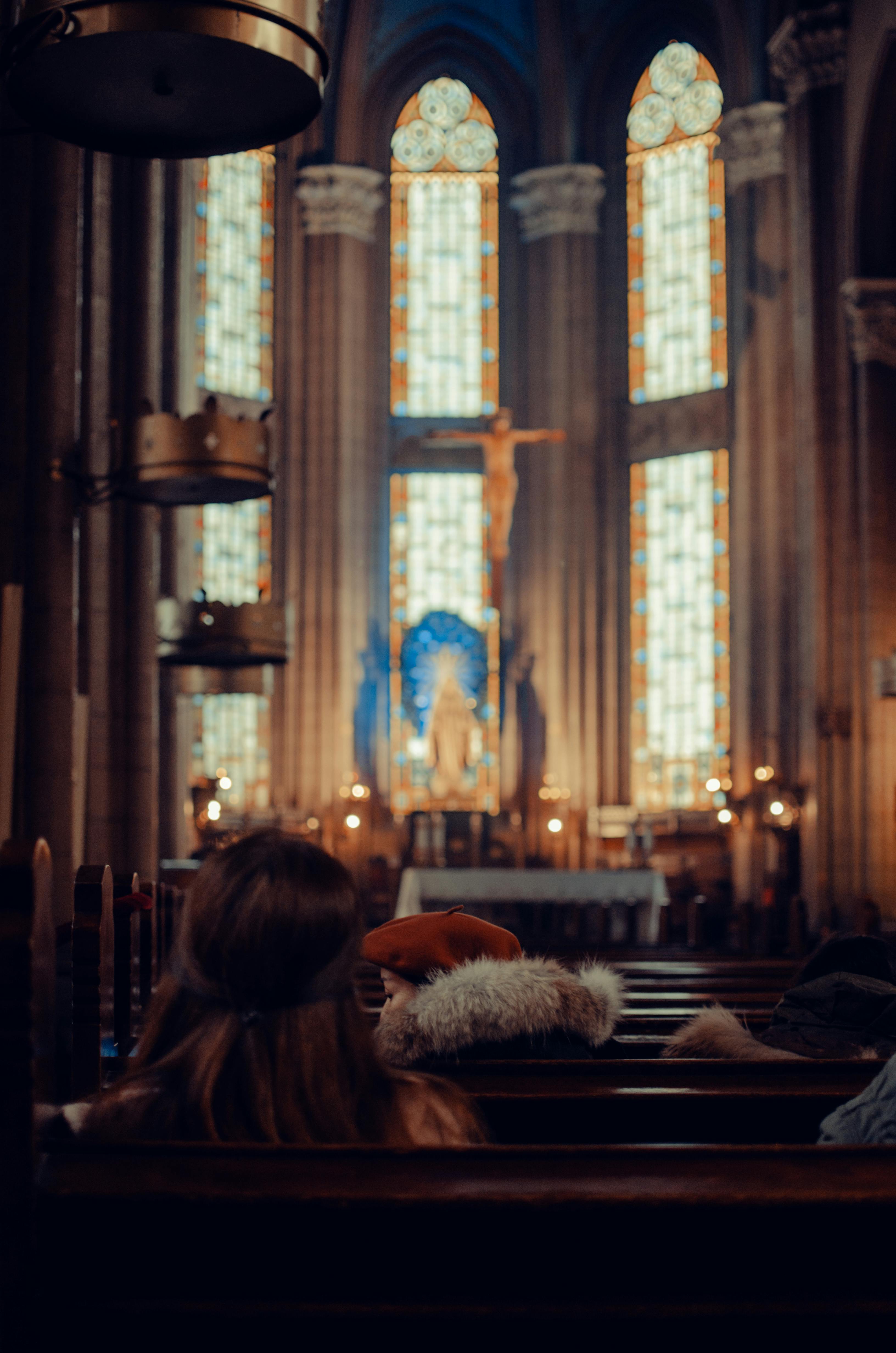 unrecognizable people in historic church with stained glass windows