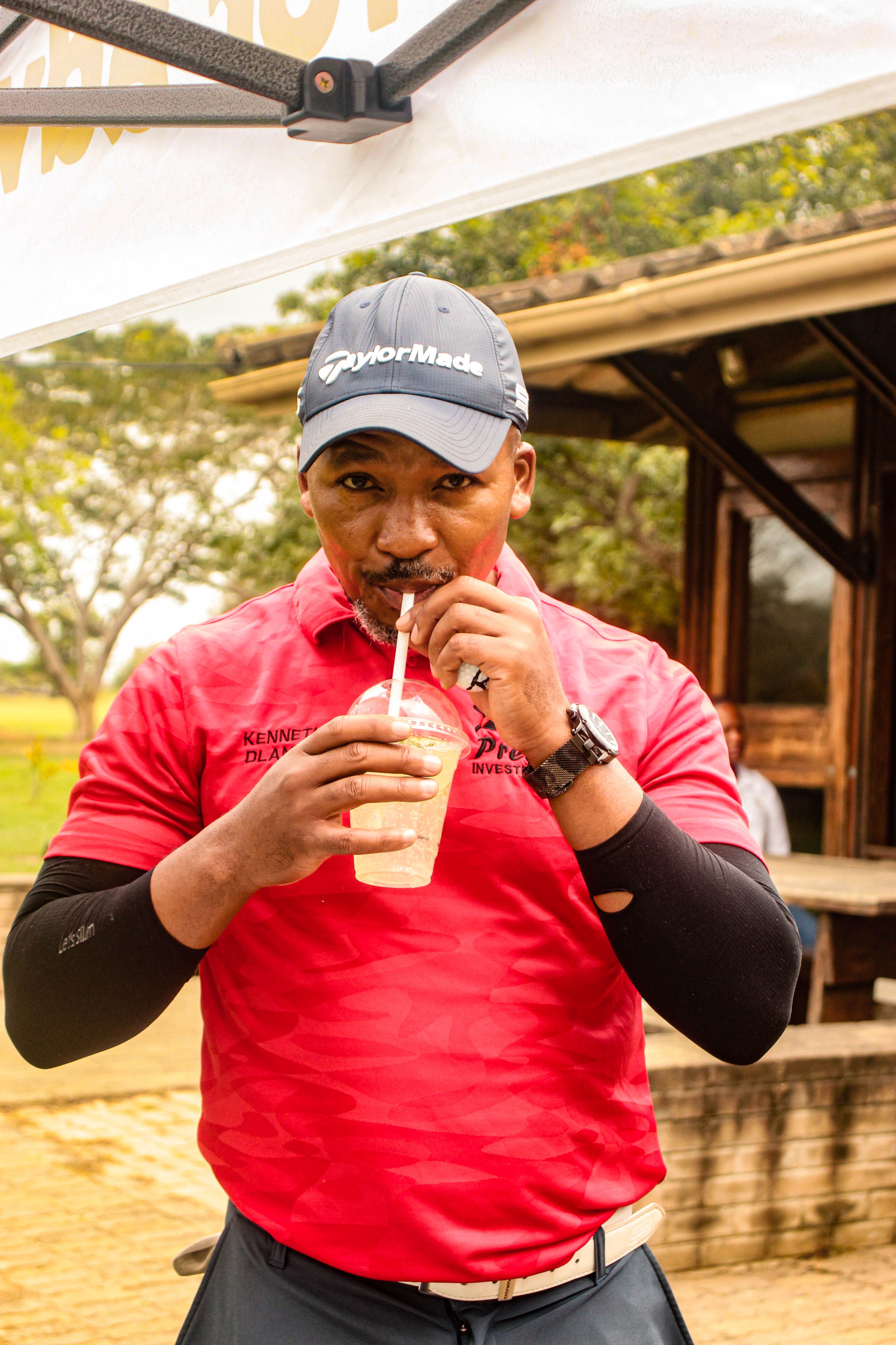 Man enjoying a refreshing drink outdoors in Malkerns, Eswatini.