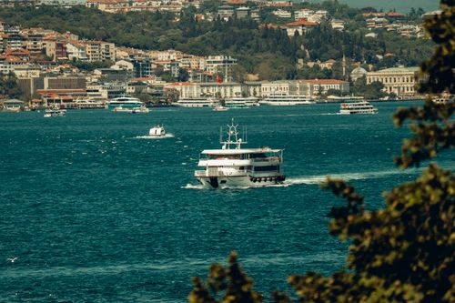 Free A picturesque view of a boat traversing the Bosphorus Strait with Istanbul cityscape in the background. Stock Photo