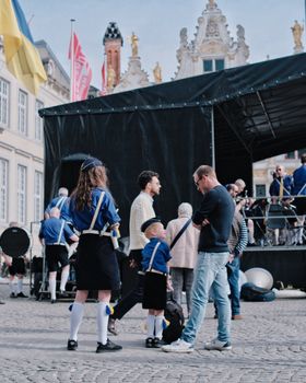 A lively outdoor band performance in Bruges, capturing the essence of a city concert with participants in uniform.