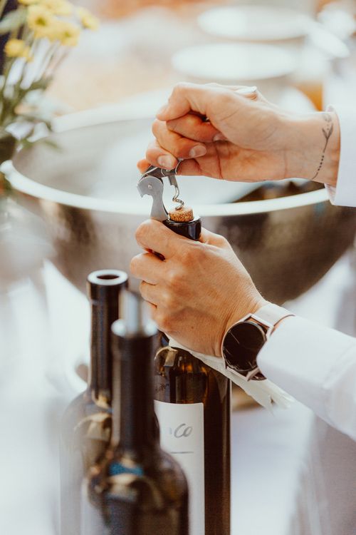 Free A sommelier skillfully opens a wine bottle during an elegant event. Stock Photo