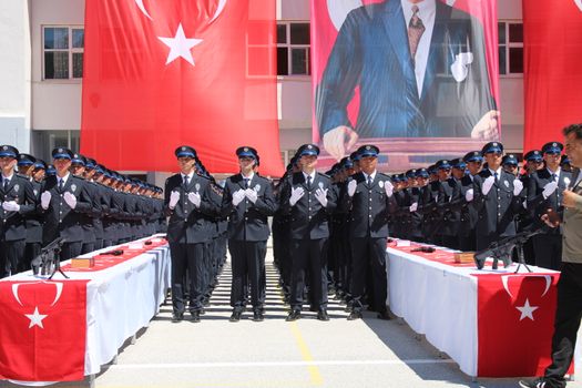 Group of Turkish police officers in uniform saluting at an official ceremony in Yozgat, Türkiye.
