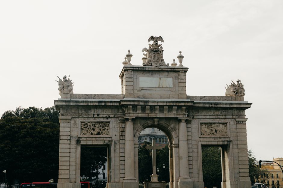 Elegante arco de piedra con esculturas en Valencia, España. Capturado a plena luz del día con detalles escénicos.