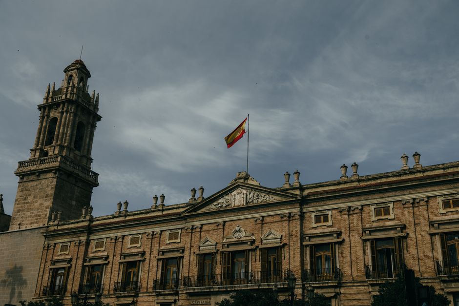 Arquitectura histórica con la bandera española en Valencia, que muestra el patrimonio cultural.