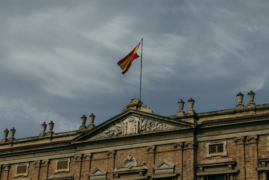 Bandera española en la cima de un edificio gubernamental histórico en Valencia, España.