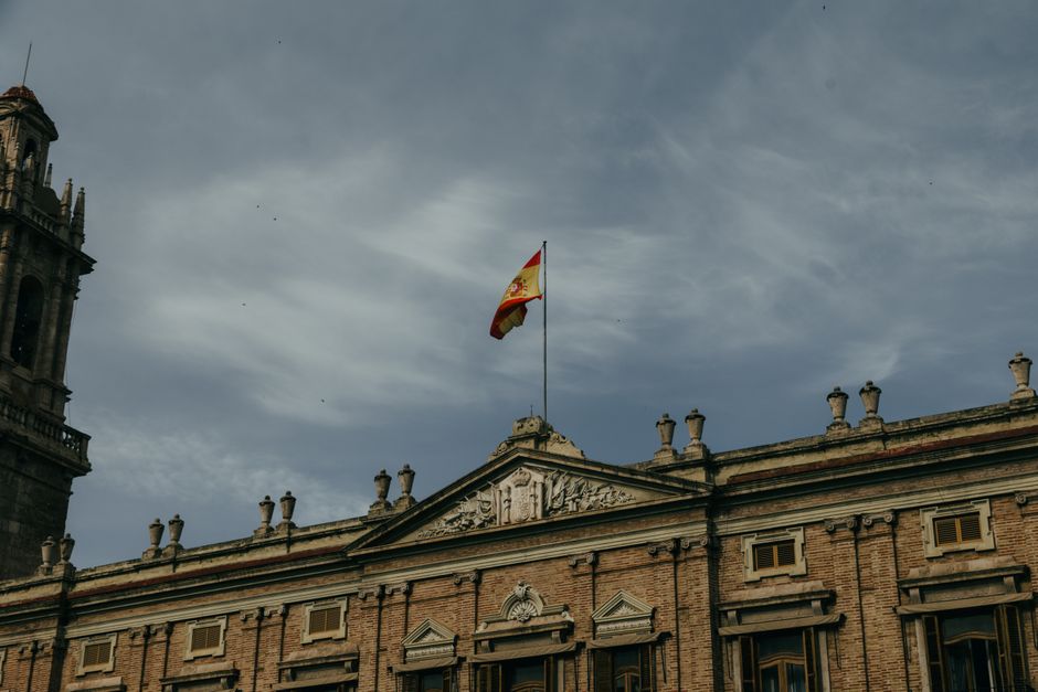 Vista desde un ángulo bajo de un edificio histórico con la bandera española en Valencia, España.