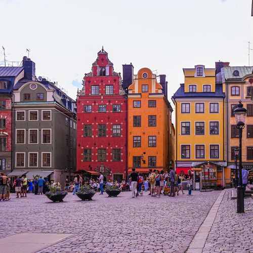 Free Vibrant facades of historic buildings in Stockholm's old town, bustling with tourists. Stock Photo