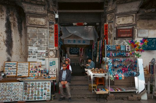 A vibrant market stall selling souvenirs and handicrafts in an ancient Chinese street.