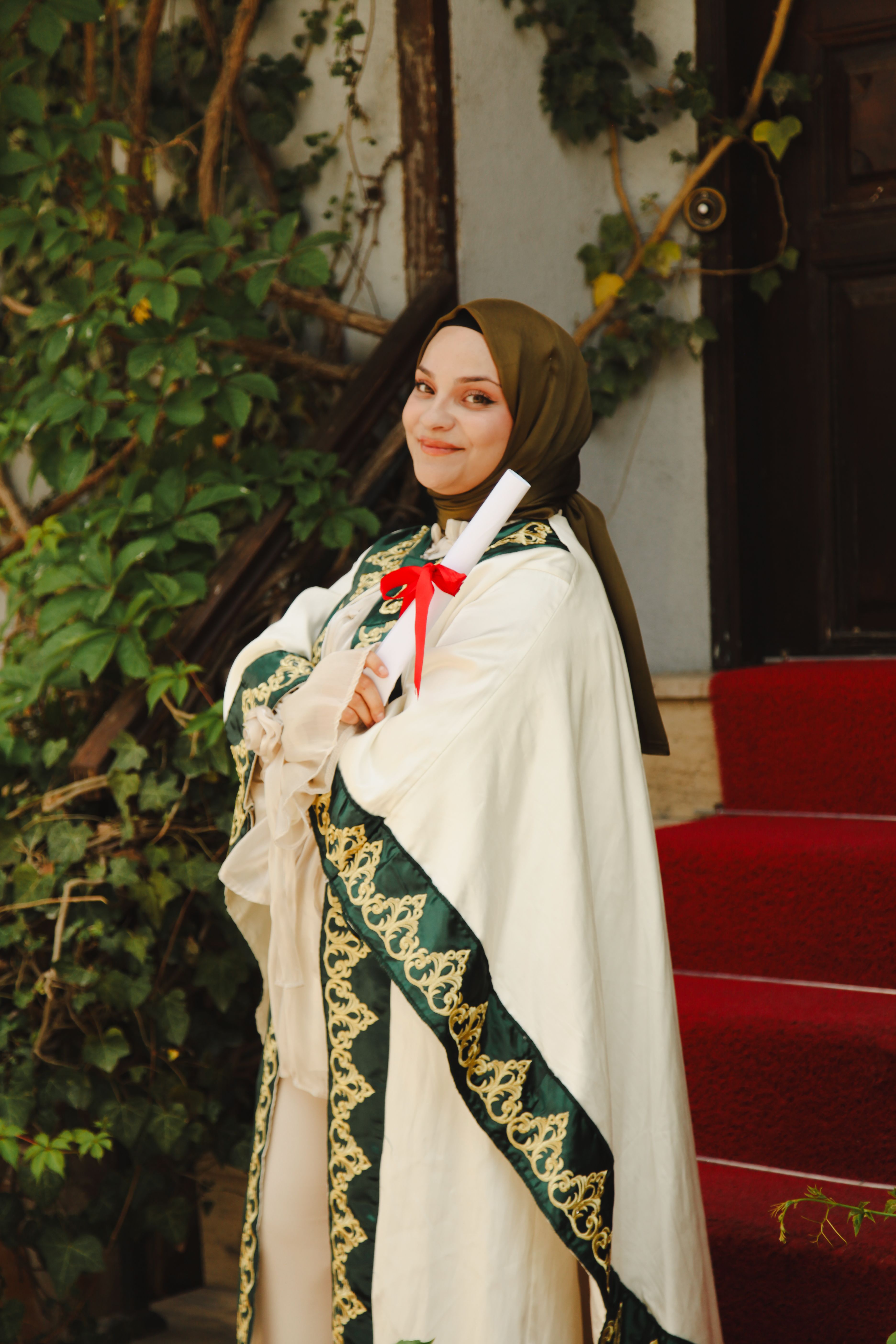 A young woman in a graduation robe celebrating her achievement with a diploma.