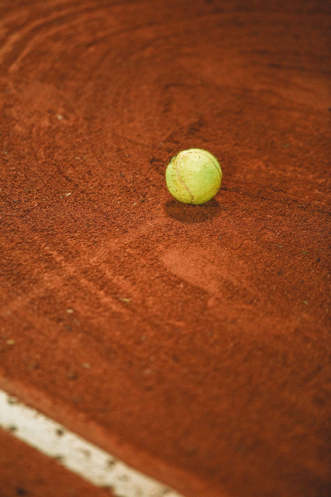 Tennis ball resting beside the court