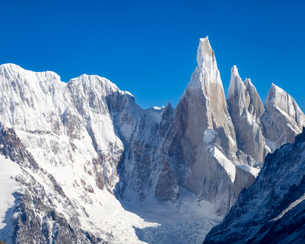 Stunning snow-capped peaks of Cerro Torre in El Chalten, Argentina, under a clear blue sky.