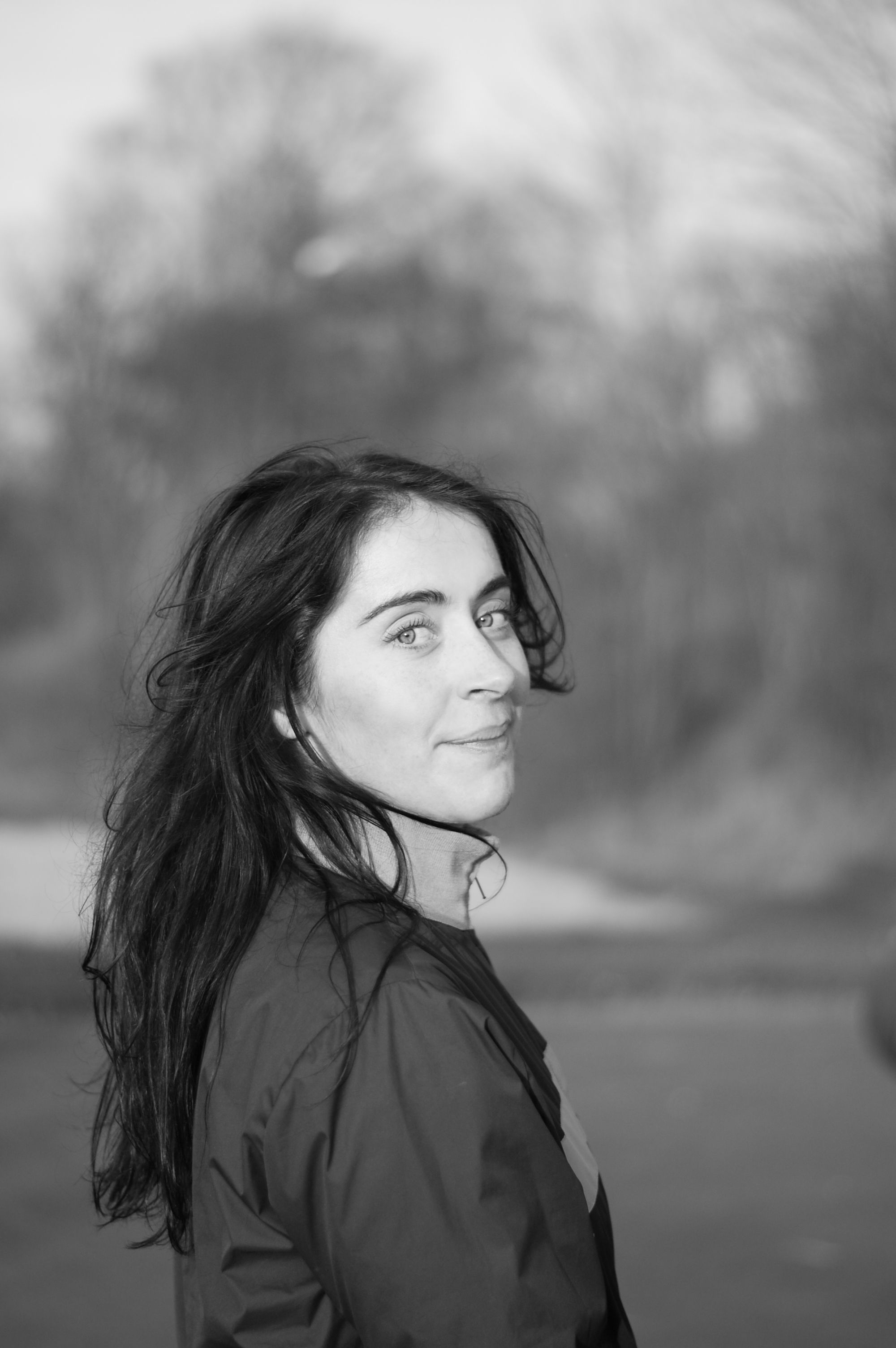 Black and white portrait of a woman outdoors, facing sideways.