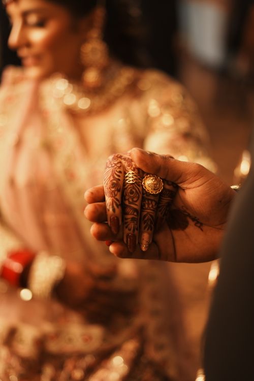Free Close-up of a beautifully adorned Indian bride and groom holding hands during a wedding ceremony. Stock Photo