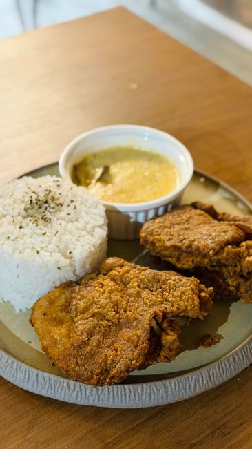 Bone-in chicken thighs braised in a dark onion gravy, served over white rice with gravy pooling on the plate.