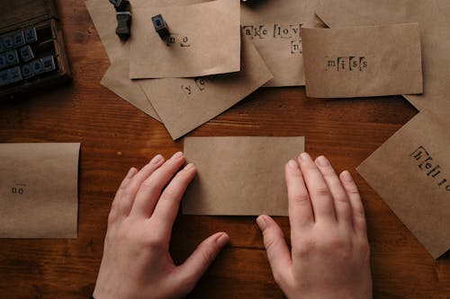 Person Using Alphabet Stamp on Brown Papers