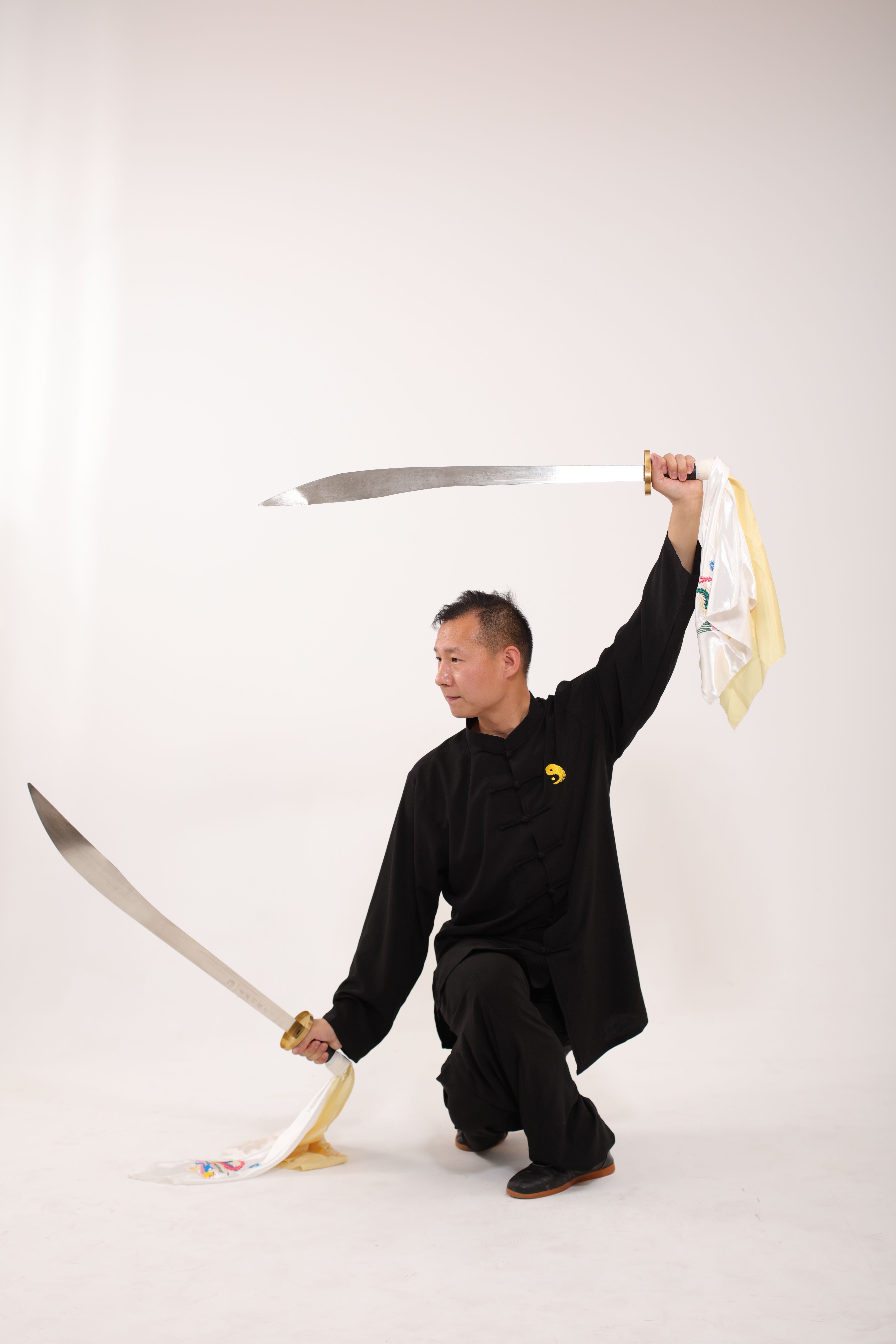 A martial artist skillfully performs a traditional sword pose indoors.