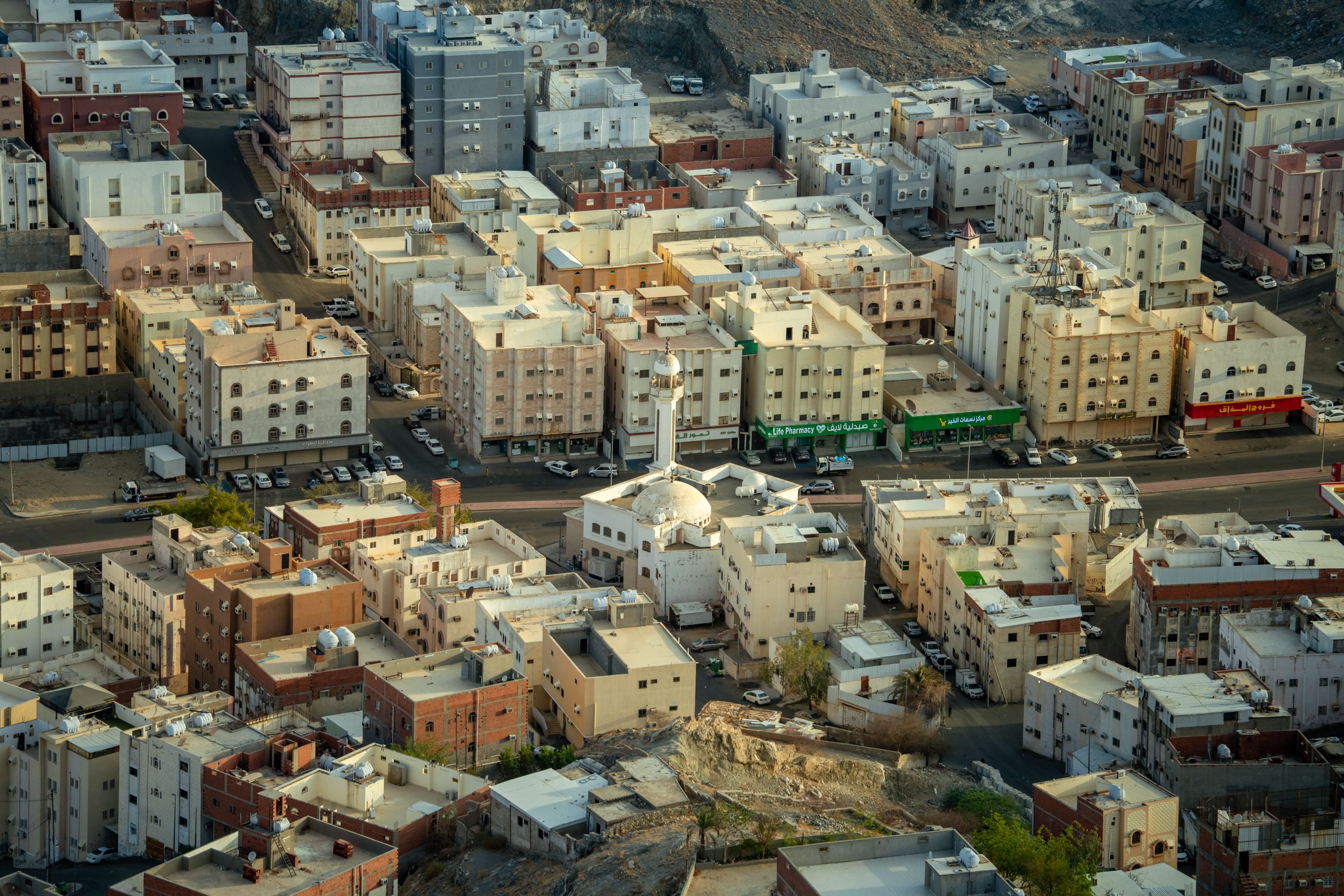 Aerial view of the urban landscape in Makkah, highlighting the dense residential area with a mosque.