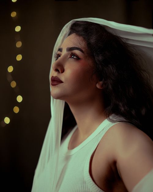 Free Artistic portrait of a woman with long hair and bokeh lights in the background. Stock Photo